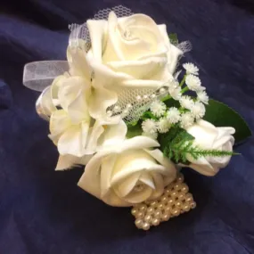 A wrist corsage featuring hydrangea & pearls plus foam roses